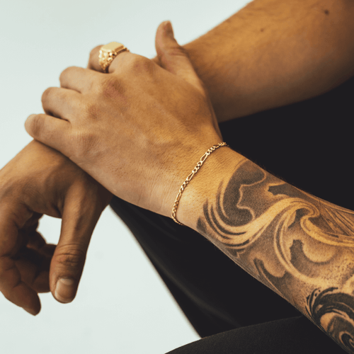 Gold Figaro bracelet featuring alternating pattern links, known for its timeless and sophisticated design-2