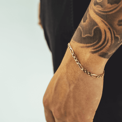 Gold Figaro bracelet featuring alternating pattern links, known for its timeless and sophisticated design-4