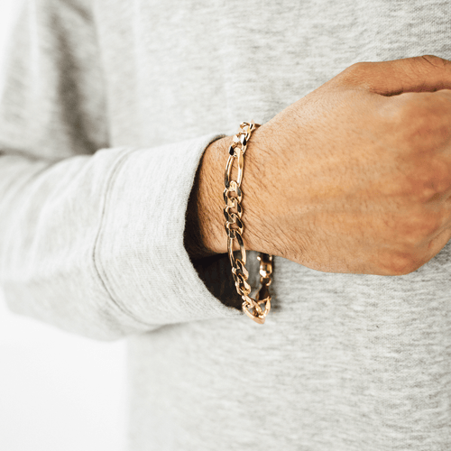 Gold Figaro bracelet featuring alternating pattern links, known for its timeless and sophisticated design